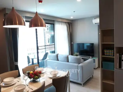 Modern living room with dining area and balcony access in a stylish apartment.
