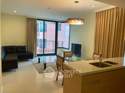Modern living room with open kitchen and balcony view in luxury apartment.
