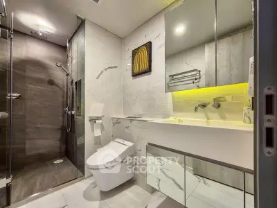 Modern bathroom with sleek design, glass shower, and elegant fixtures.