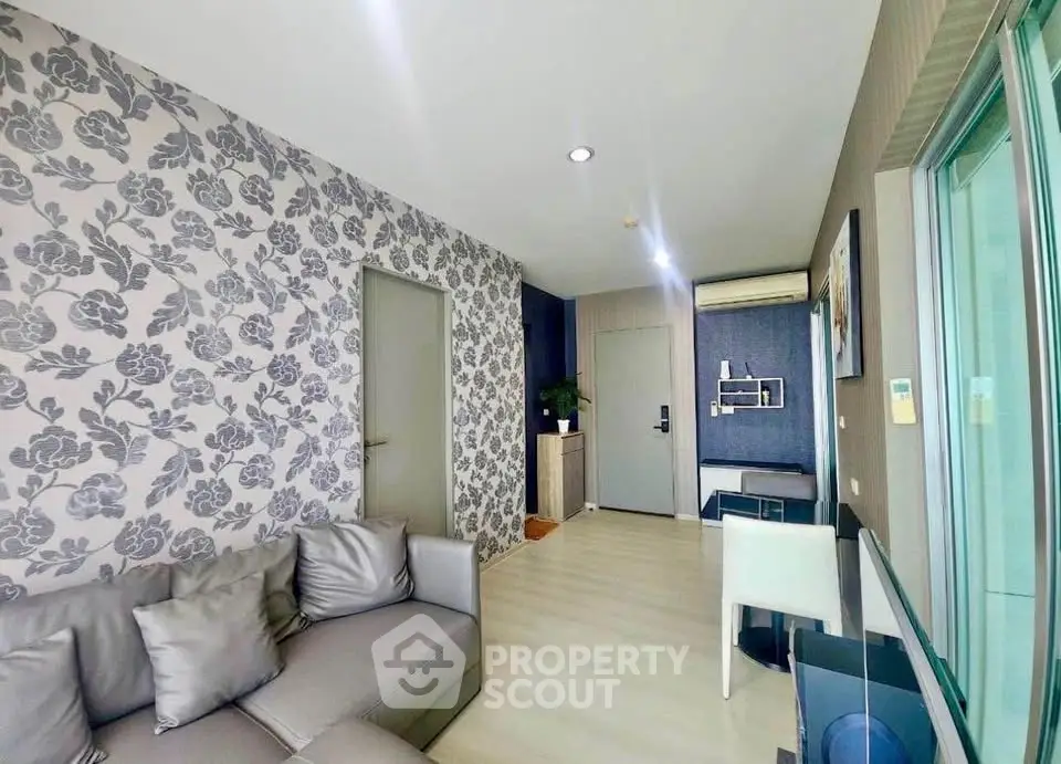 Modern living room with stylish wallpaper and cozy gray sofa in a contemporary apartment.