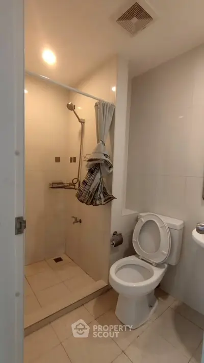 Modern bathroom with shower and toilet in a sleek, minimalist design.
