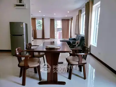 Spacious dining area with elegant wooden furniture and natural light in modern home.