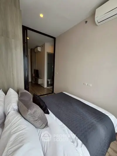 Modern bedroom with stylish decor and air conditioning in a contemporary apartment.