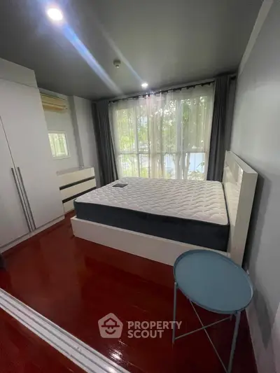 Cozy bedroom with large window and modern furnishings, perfect for relaxation and comfort.