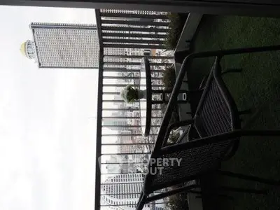 Stunning city view from a modern balcony with stylish outdoor furniture.