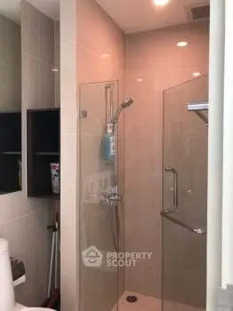 Modern bathroom with glass shower enclosure and sleek fixtures.