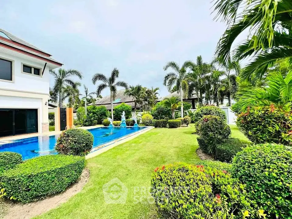 Luxurious villa with lush garden and private pool in tropical paradise setting.