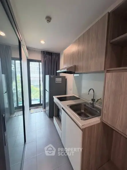 Modern kitchen with sleek cabinetry and large windows offering natural light.