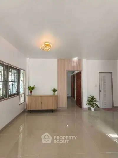 Spacious living room with modern lighting and elegant decor, perfect for a cozy home atmosphere.