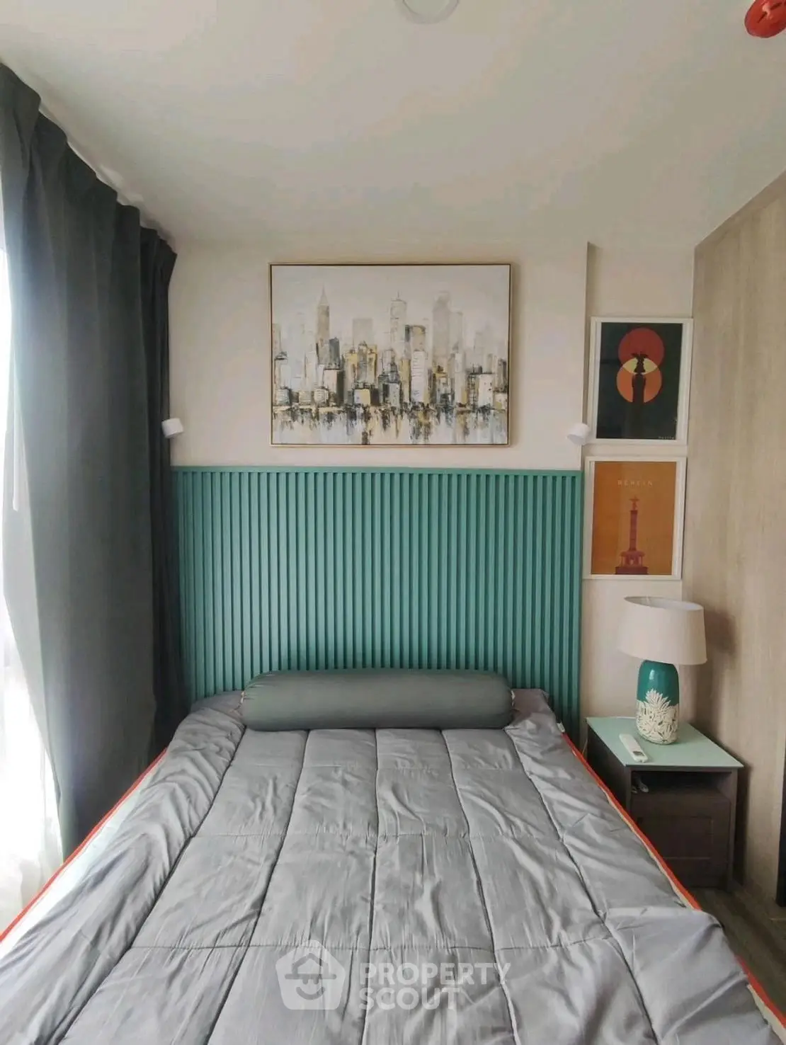 Cozy bedroom with modern decor and cityscape artwork above bed