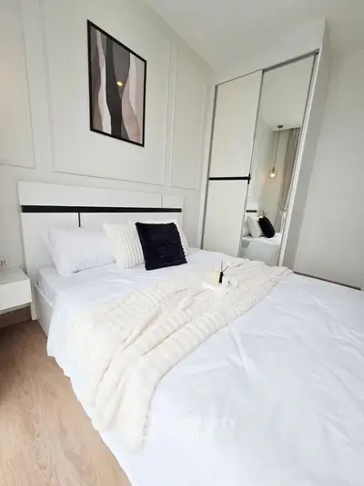 Modern bedroom with stylish decor and mirrored closet doors.