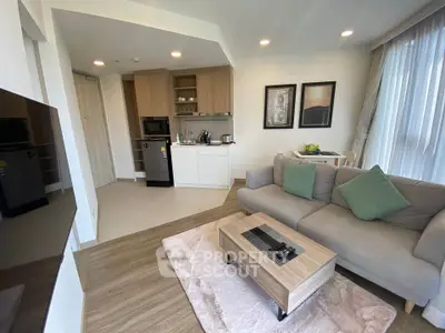 Modern living room with open kitchen, cozy sofa, and stylish decor in a bright apartment.