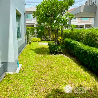 Charming garden view of a modern suburban home with lush greenery and manicured hedges.