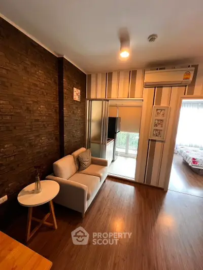 Cozy living room with modern decor and natural light, featuring a comfortable sofa and stylish wall accents.