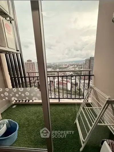 Charming balcony with artificial grass and city view, perfect for relaxation.