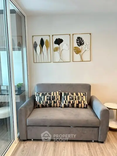 Modern living room with stylish sofa and decorative wall art in a cozy apartment.