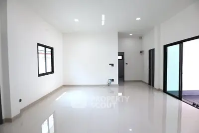 Spacious modern living room with sleek tile flooring and large windows.