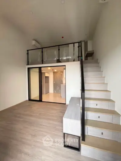 Modern loft-style apartment with mezzanine and sleek staircase