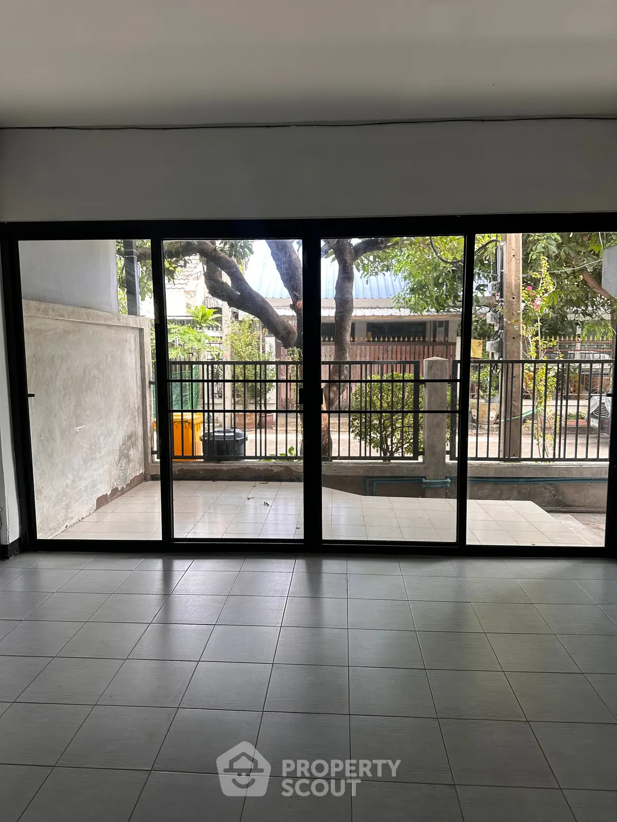 Spacious room with large glass doors opening to a serene outdoor view, perfect for natural light lovers.