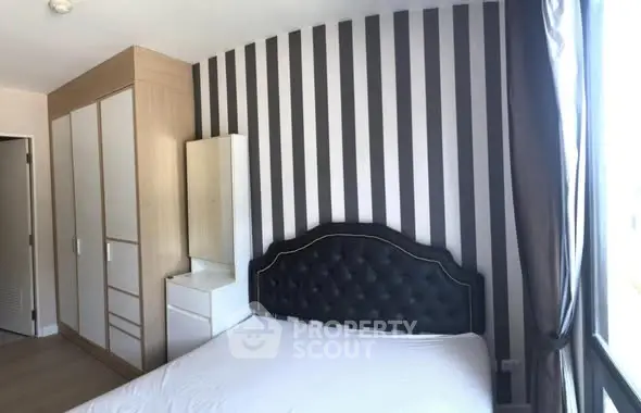 Modern bedroom with stylish striped wallpaper and elegant headboard