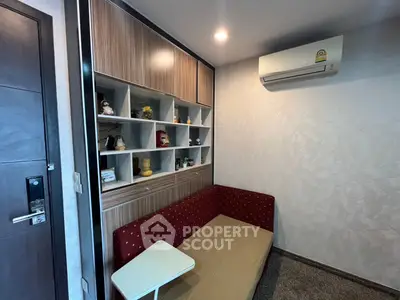Cozy living room with built-in shelving and air conditioning unit, perfect for relaxation.
