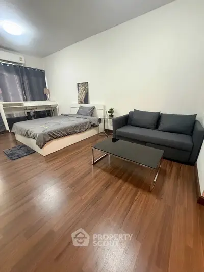 Modern studio apartment with cozy bed and stylish sofa, perfect for urban living.