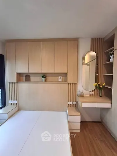 Modern bedroom with sleek wooden cabinetry and stylish vanity area