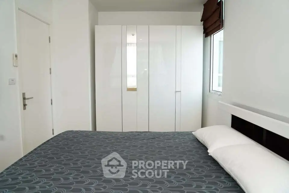 Modern bedroom with sleek white wardrobe and stylish bedding