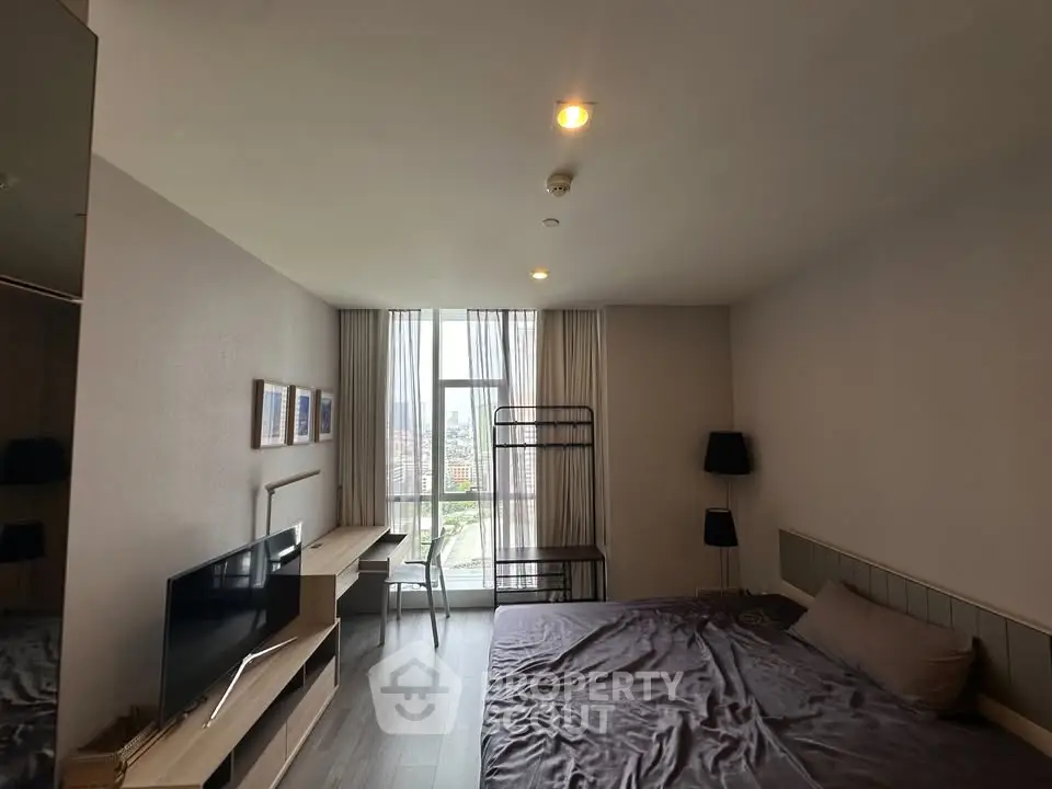Spacious bedroom with city view, modern furnishings, and ample natural light.