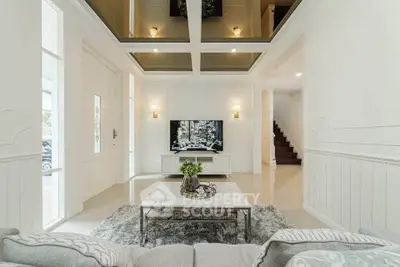 Luxurious living room with high ceiling and elegant decor, featuring a modern TV setup and plush seating.