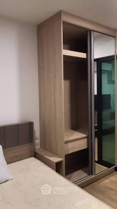 Modern bedroom with sleek wooden wardrobe and comfortable bed in stylish apartment.
