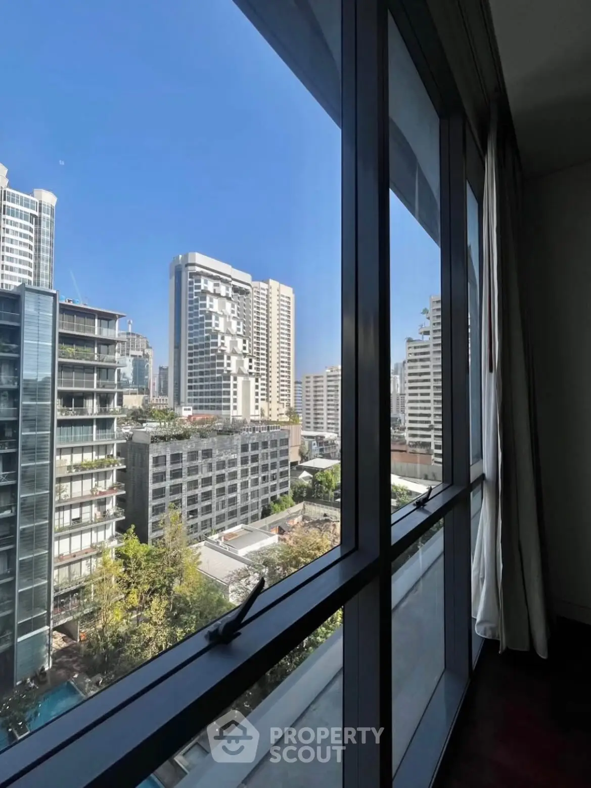 Stunning cityscape view from a modern high-rise apartment window, showcasing urban living at its finest.