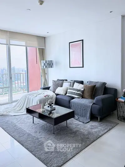 Modern living room with stylish decor and city view balcony.