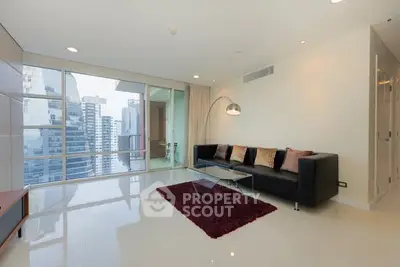 Modern living room with city view, sleek furniture, and floor-to-ceiling windows.
