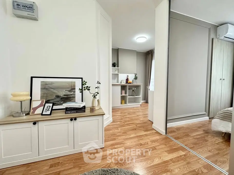 Modern living room with stylish decor and wooden flooring, featuring a cozy ambiance and ample natural light.