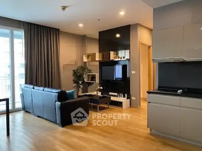 Modern living room with sleek design and open kitchen layout in a stylish apartment.