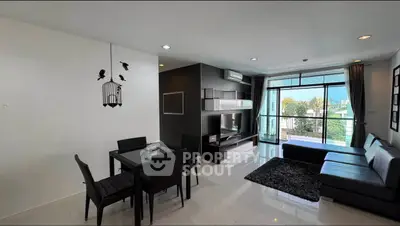 Modern living room with sleek black furniture and large windows offering a stunning view.