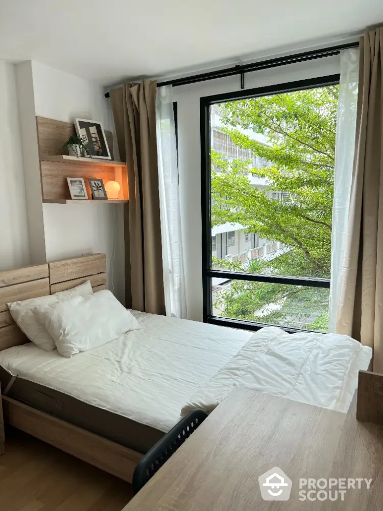 Cozy bedroom with large window and natural light in modern apartment