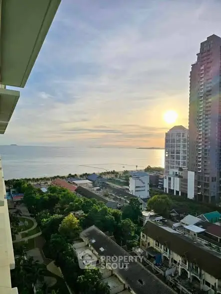 Stunning high-rise view of cityscape and ocean at sunrise, perfect for urban living.