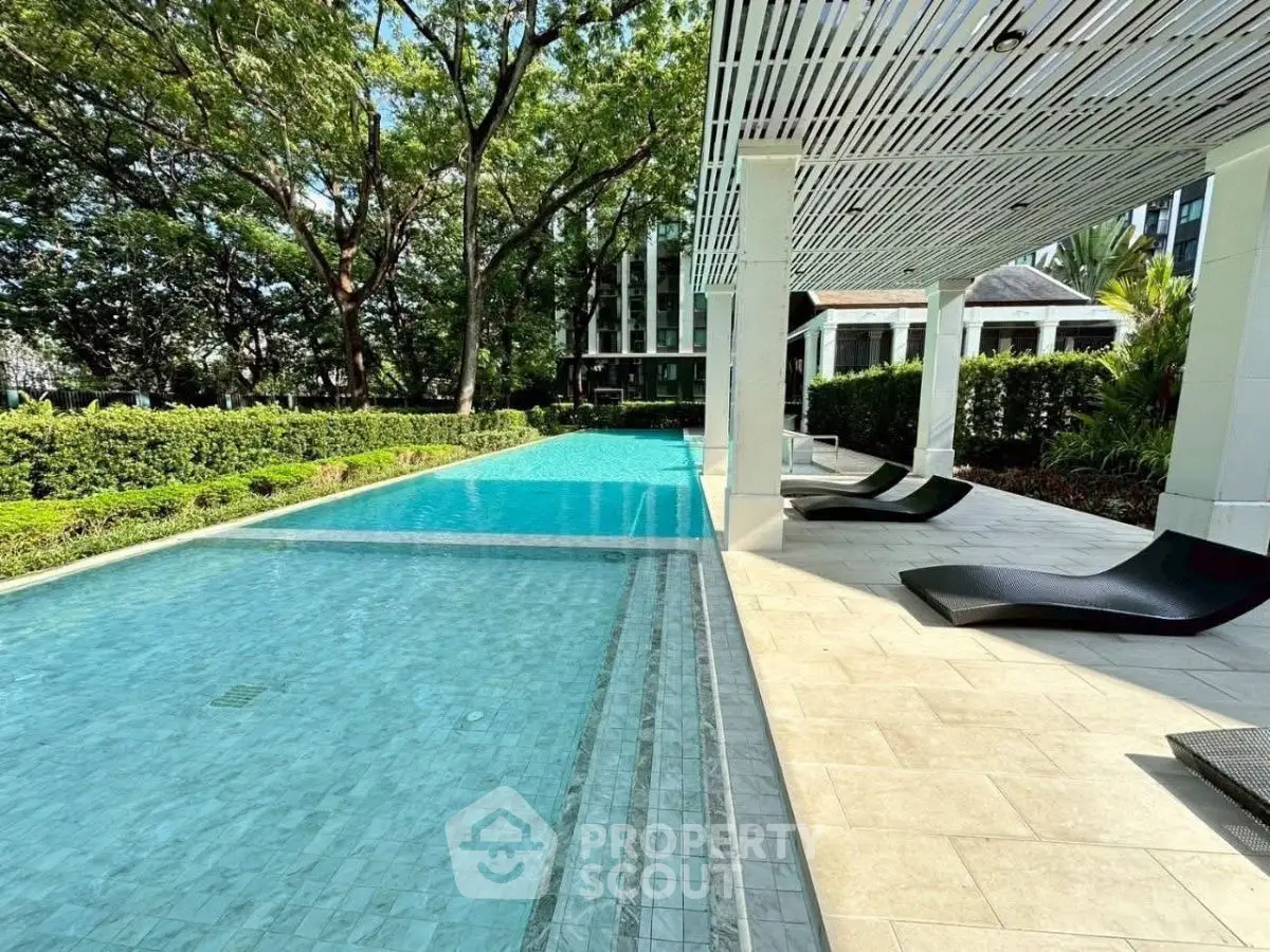 Luxurious outdoor pool area with modern loungers and lush greenery