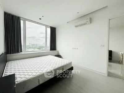 Spacious bedroom with large window offering stunning city views, modern air conditioning, and sleek flooring.