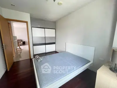 Modern bedroom with sleek wardrobe and hardwood floors in a stylish apartment