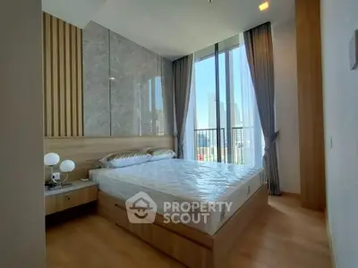 Modern bedroom with floor-to-ceiling windows and city view, featuring elegant decor and natural light.