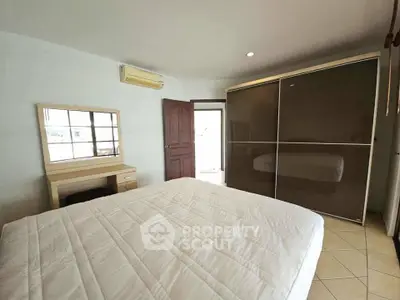 Spacious bedroom with modern wardrobe and air conditioning unit.