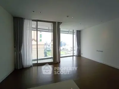 Spacious living room with large windows offering city views and abundant natural light.