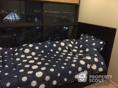 Cozy bedroom with large windows offering a stunning night city view, perfect for relaxation after a long day.