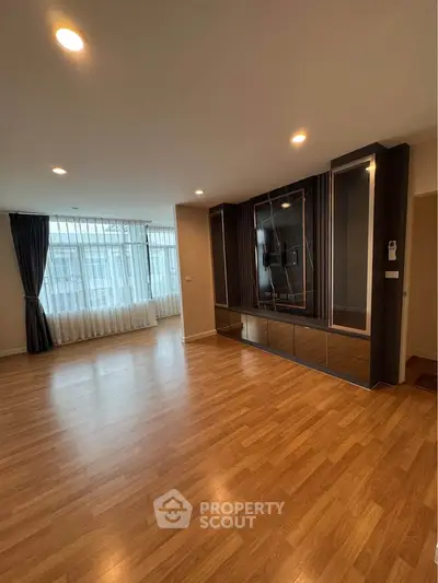 Spacious modern living room with wooden flooring and large windows