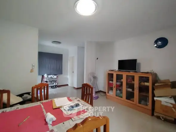 Spacious living room with dining area and modern furnishings in a cozy apartment.