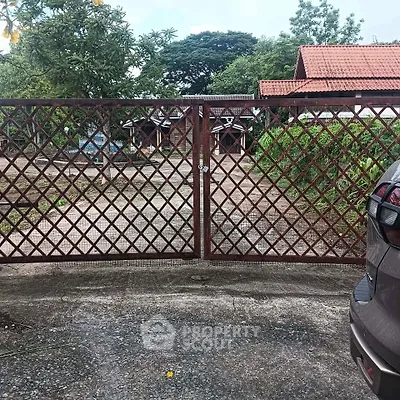 Charming rustic property with gated entrance and lush greenery, perfect for serene living.
