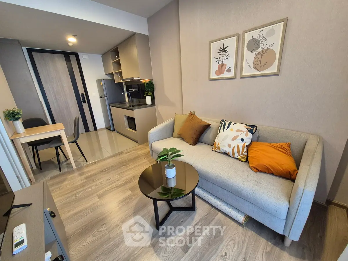 Modern living room with stylish decor and compact kitchen area, perfect for urban living.